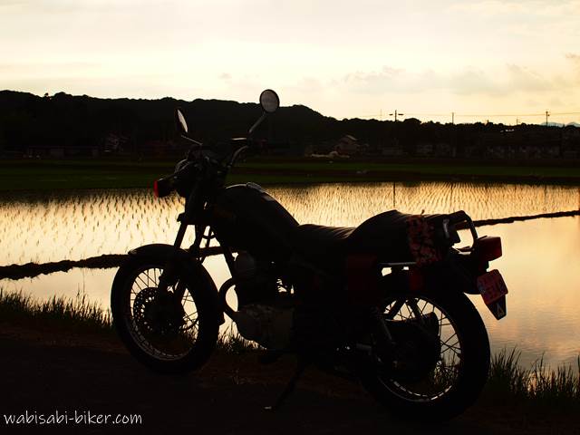 夕焼けの田んぼとオートバイ