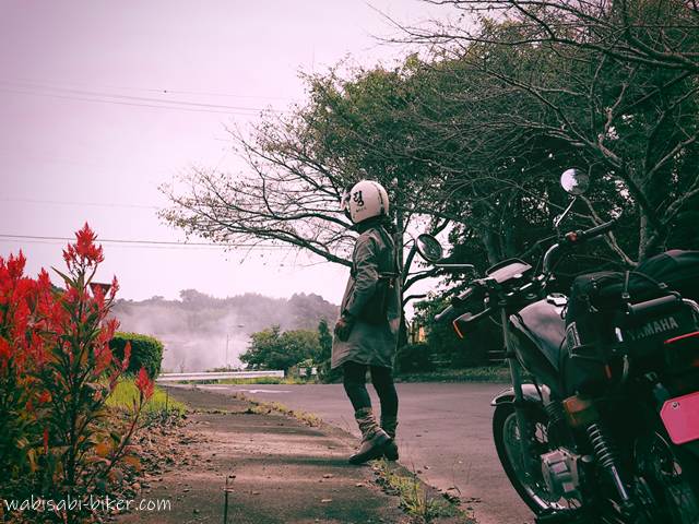 ケイトウと稲わら焼きの煙と女性バイク乗り