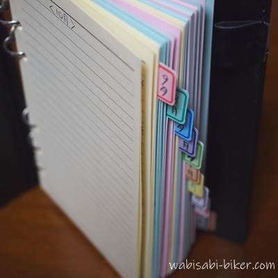 月ごとにカラフルなインデックスが付けられたA5サイズのリフィルファイル。10年分のページ枚数の厚みが感じられる。