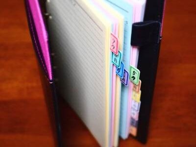 10年分のバイク写真記録が綴じられたA5サイズのリフィルファイル。カラフルなインデックスで各月が区分され、ファイルの表紙はピンク色。