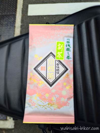 黒いバイクのシート上に置かれた、新茶「川根茶」のピンク色の茶袋。購入記念の一枚