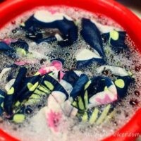 花柄アロハを匂い消しのため、赤いバケツで食器用洗剤につけ置きしている写真