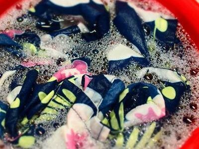 花柄アロハを匂い消しのため、赤いバケツで食器用洗剤につけ置きしている写真