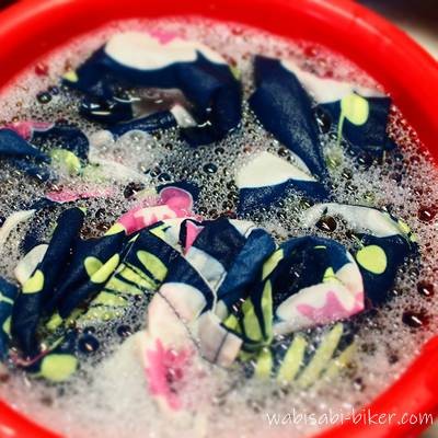 花柄アロハを匂い消しのため、赤いバケツで食器用洗剤につけ置きしている写真