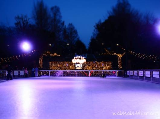 夕暮れの山下公園に設置されたWinter Wonder Park Yokohamaの屋外スケートリンク。リンク中央に装飾ライトがあり、周囲をイルミネーションと観客スペースが囲んでいる。