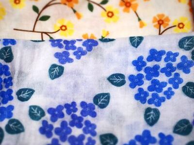 紫陽花柄（手前・120円）と、黄色い花柄・青い花柄（奥・各250円）のガーゼ手ぬぐいを重ねた写真