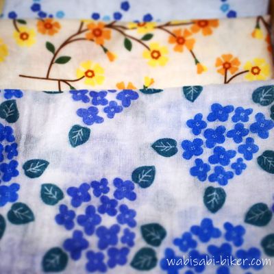 紫陽花柄(手前・120円)と、黄色い花柄・青い花柄(奥・各250円)のガーゼ手ぬぐいを重ねた写真