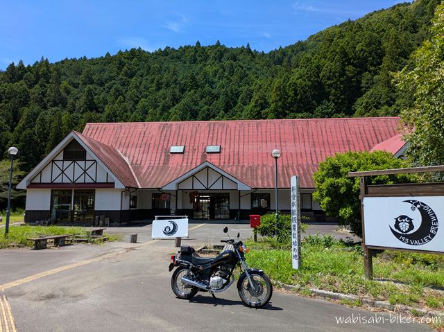 193 VALLEY BREWING前に停めたヤマハSR125。赤い屋根と緑の山を背景にした写真。
