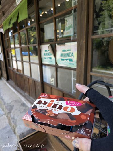 昔の商店を思わせる木枠の引き戸が残る「二俣ステーション 土間de」で、購入したアイスを手に持つ様子