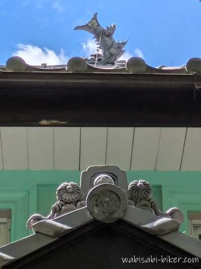 二俣公会堂の屋根にある鯱鉾と瓦飾り。緑色の外壁も写った写真。