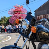 御前崎市の秋祭りで、華やかな祭り屋台と人々を背景に停めた黒いバイクSR125。